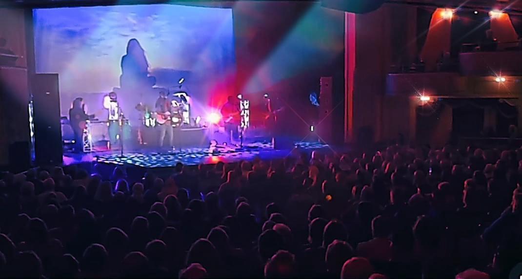 Full theater — sky backdrop, packed house